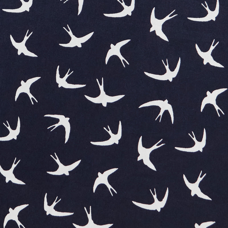 Swatch of bold white flying swallow birds print in 100% cotton poplin by Rose and Hubble in Navy blue