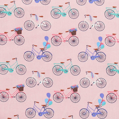 Swatch of colourful bicycles and balloons print 100% cotton poplin fabric in pink