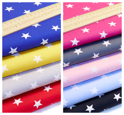 Brilliant, bold star printed 100% cotton poplin fabric by Rose and Hubble in Pink, Cerise, Pale Blue, Royal Blue ,Silver, Dark Grey, Yellow, Red & Black