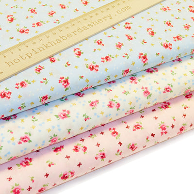 Vintage-style roses & bows print, dotted with tiny confetti hearts in 100% cotton poplin fabric by Rose and Hubble in ivory, pink and blue.