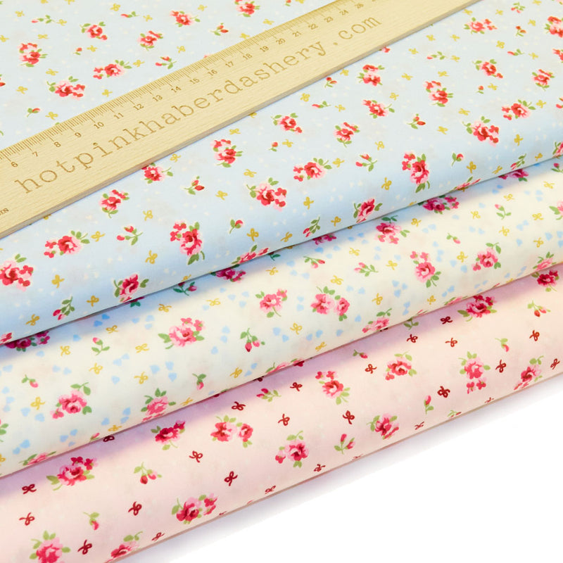 Vintage-style roses & bows print, dotted with tiny confetti hearts in 100% cotton poplin fabric by Rose and Hubble in ivory, pink and blue.