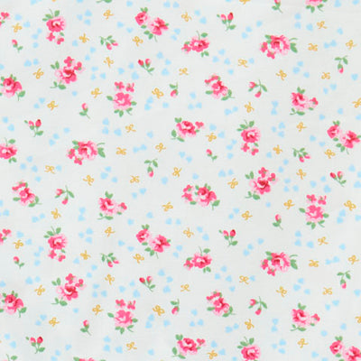 Swatch of vintage-style roses & bows print, dotted with tiny confetti hearts in 100% cotton poplin fabric by Rose and Hubble in ivory