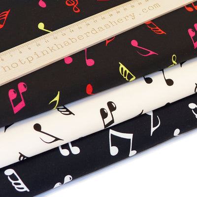 Colourful, bold and retro musical note print 100% cotton poplin fabric by Rose and Hubble with clefts and quavers in black, ivory and multicoloured
