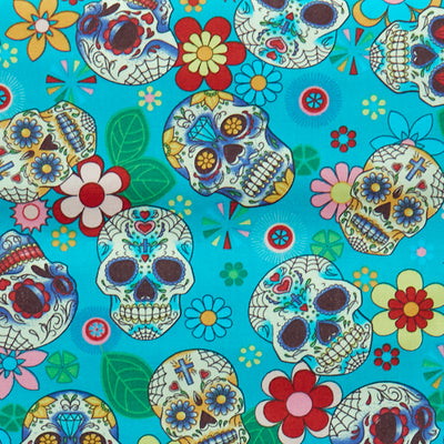 Swatch of Mexican festival-inspired 'Dia De Los Muertos' print with skulls and flowers on 100% cotton poplin fabric by Rose and Hubble in turquoise blue and multicolour, Halloween fabric, skull fabric