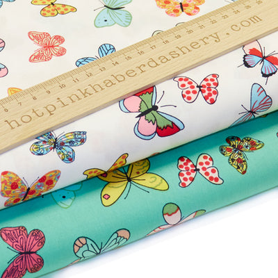 Cute and colourful, patterned butterflies on 100% cotton poplin fabric by Rose and Hubble in mint green and ivory