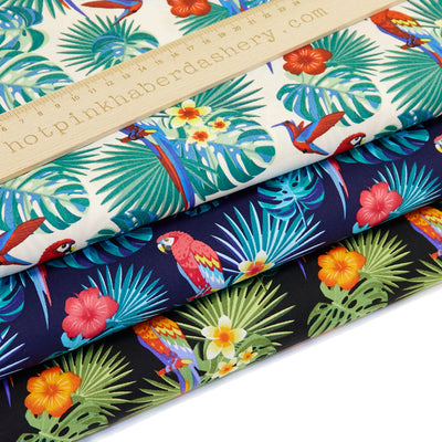 Bold and colourful tropical print with parrots, hummingbirds, frangipani flowers and palm leaves.100% cotton poplin fabric by Rose and Hubble in white, navy and black