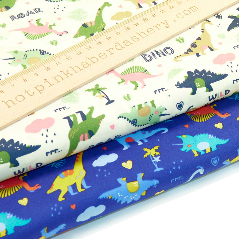 Cute, illustrated dinosaur pattern with hearts, clouds, roar print and palm trees on 100% cotton poplin fabric by Rose and Hubble on Royal blue and Ivory, dinosaur fabric, children&