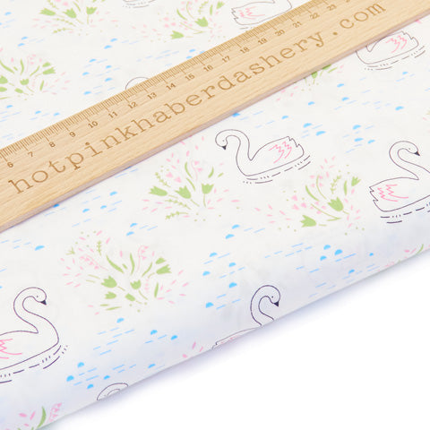 Delicate drawn swan print with water ripples and flowers on 100% cotton poplin fabric by Rose and Hubble on white
