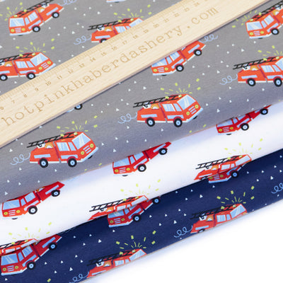 Fun, children's illustrated red fire engines printed on jersey fabric by John Louden in Ivory, navy and grey