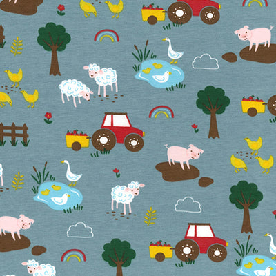 Swatch of fun, children's storybook farmyard print with tractors, pigs, sheep, chickens and trees on jersey fabric by John Louden in blue