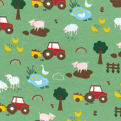 Swatch of fun, children's storybook farmyard print with tractors, pigs, sheep, chickens and trees on jersey fabric by John Louden in green
