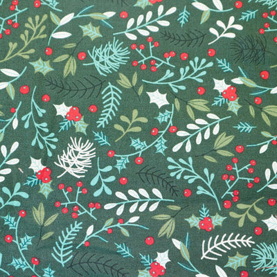 Swatch of Christmas winter foliage print with holly, berries, eucalyptus and fir leaves on green. Rose and Hubble 100% cotton poplin fabric.