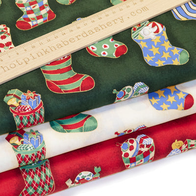 Classic festive toys In Christmas Stockings printed Rose & hubble 100% Cotton poplin fabric in red, cream and green 