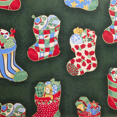 Swatch of classic festive toys In Christmas Stockings printed Rose & hubble 100% Cotton poplin fabric in green