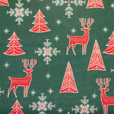 Swatch of scandi red reindeer, snowflakes, stars and Christmas trees in 100% cotton poplin fabric by Rose & Hubble in and green