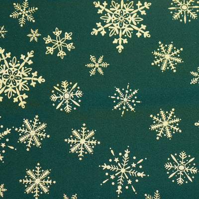 Falling golden and shiny, winter snowflakes on festive dark green 100% cotton poplin fabric by Rose & hubble