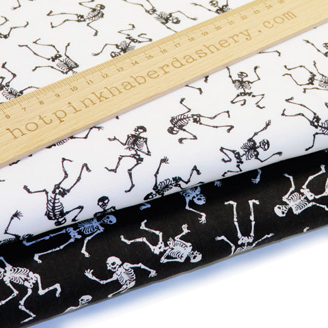 Dancing, spooky Halloween skeletons on polycotton fabric in white and black